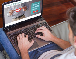 man on laptop looking at dental insurance