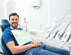 Male dental patient sitting in chair and smiling