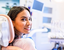 Female patient looking back while sitting in dental chair